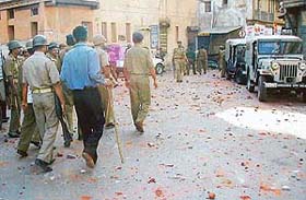 Paramilitary personnel patrol a street