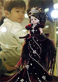 A baby looks at "Licca-chan" doll