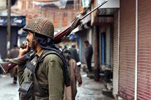 A security jawan stands guard outside closed shops