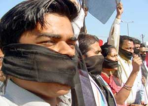 Congress activists wear black scarves during a demonstration
