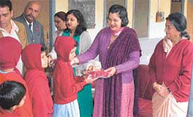 Ms Sunil Agarwal, Chairperson District Red Cross Society, disburses sweets and garments among deaf and dumb children at Bal Bhavan
