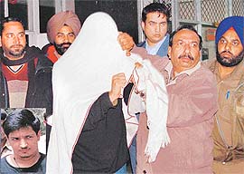 Ranjit Bajaj (inset), son of a senior bureaucrat couple in Punjab, hides his face while being taken for a medical examination at the Sector 16 General Hospital, Chandigarh