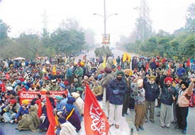 Members of employees unions block traffic on the Ferozepore Road in front of Gate 1 of Punjab Agricultural University