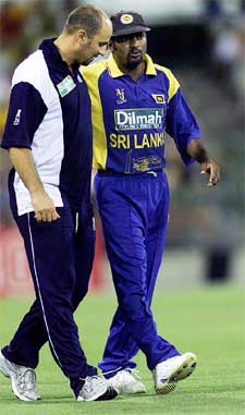 Sri Lankas Muttiah Muralitharan is helped from the field
