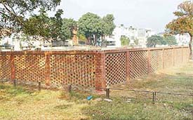 A newly constructed brick enclosure for dumping garbage in Sector 27 on a green belt that has become an eyesore