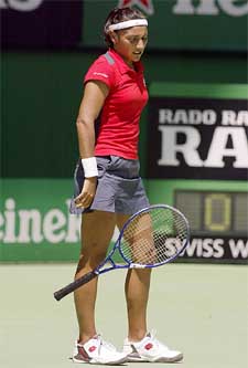 Paola Suarez from Argentina throws her racket after hitting a shot out