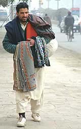 A Kashmiri migrant sells traditional warm jackets