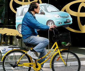 A man pedals past a motor showroom in Hong Kong on Tuesday. 