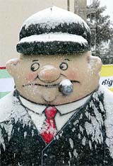 An inflatable puppet representing a businessman with a cigar