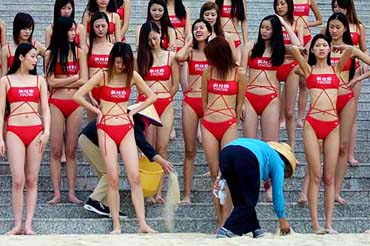 Chinese models wait for workers to prepare a location set