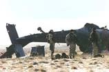 US soldiers stand next to the wreckage of a US Army UH-60 "Black Hawk" helicopter that crashed in east of Bagram Air Base in Afghanistan