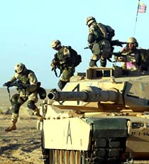 US Army soldiers jump from an M1A1 Abrams tank during an urban warfare training course in the north Kuwait desert