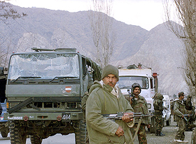 Army jawans stand near their damaged vehicle
