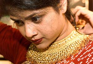 A customer tries on a handmade gold ornament