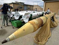 A foreign journalist walks around a displayed missile