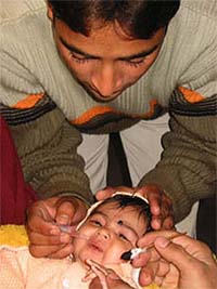 A doctor administers pulse polio drops to an infant