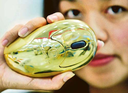 DATA IT employee displays a gold-plated computer mouse at its unveiling in Bangkok