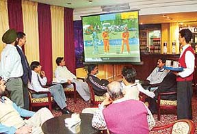 Even the waiter’s eyes are on the giant screen: Guests enjoy food and cricket at Hotel Sunbeam, Sector 22