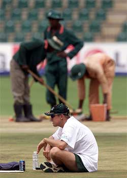 Zimbabwe batsman Andy Flower sits on the cricket pitch during a practice session
