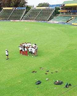 Zimbabwe cricketers have a team talk in the empty Harare Sports Club stadium