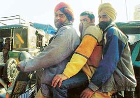 A city youth hides his face while being taken away by the police