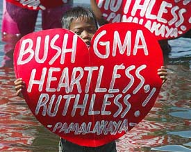 A boy displays heart-shaped placard during a bayside protest in the shallow waters off Manila Bay 