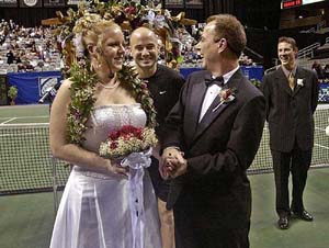 Tennis star Andre Agassi congratulates couple Lorri Barnett and David Hagan after their Valentine's Day wedding at center court 