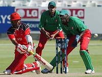 Canadian cricket captain Joe Harris gets his shot away past Kenyan wicketkeeper David Obuya 