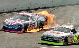 Engulfed in flames, Stacy Compton in the Kingsford/Johnsonville Chevrolet (59) drives through the second turn 