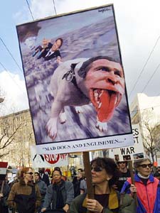 An anti-war demonstrator carries a large Bush sign at a peace rally 