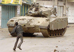 A Palestinian throws stones towards an Israeli tank