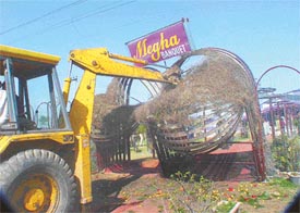 A JCB machine brings down an illegal structure of a marriage palace near Baddowal