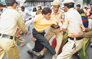 A blind person being manhandled by the police