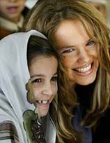 Miss Germany, Alexandra Vodjanakova, sits with an Iraqi child in Baghdad 