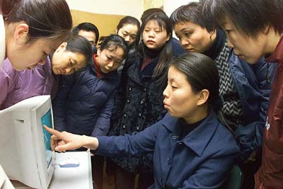Laid-off workers are shown how to use the computer at a retraining centre in Xian, the capital of China's Shaanxi province. 