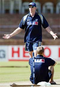 Australias Glenn McGrath gestures as team-mate Mathew Hayden sits in front of a stump at Queens Sports Club in Bulawayo
