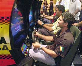 Indian batsman Sachin Tendulkar plays a driving simulation video game 