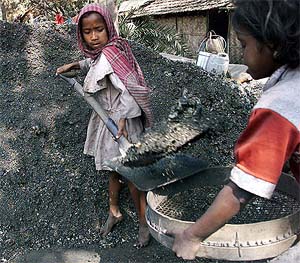 Seven-year-old child labourer Basumati transfers pieces of coal
