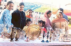 Women have a close look at crystal and brassware at a stall in the craft fair in Patiala