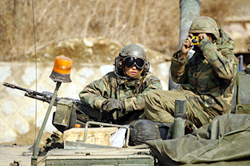 A US soldier from 2nd Infantry Division takes a picture while sitting on his Abrams battle tank 