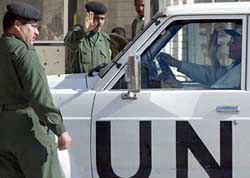 Iraqi soldiers salute to UN weapons inspectors as they arrive to search the al-Qaqa missile site
