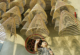 A Malaysian Chinese boy plays with spiral joss sticks