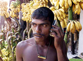 A labourer working in Colombos wholesale market uses a mobile phone