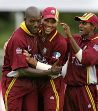 Caribbean fast bowler Vasbert Drakes is congratulated by team mate Ricardo Powell and Shivnarine Chanderpaul 