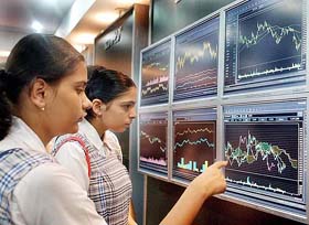 Schoolgirls look at stock market graphs displayed on plasma screens 