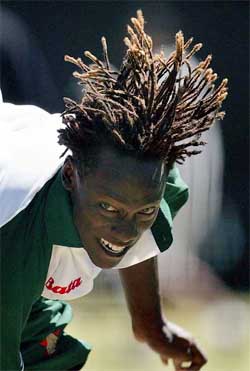 Zimbabwe bowler Henry Olongas hair flies as he bowls in the nets 
