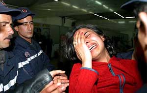 A young Algerian woman assisted by firefighters at Algiers airport