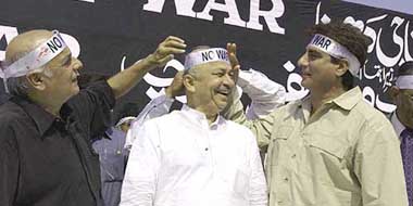 Filmmaker Mahesh Bhatt and actor/politician Raj Babbar tie a 'no war' band on the forehead of Maharashtra Chief Minister