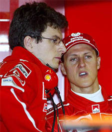 Germany's Michael Schumacher talks with a Ferrari team mechanic