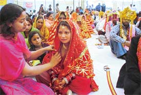 A volunteer arranges the dupatta of a bride during a mass-marriage function at Nishkam Sewa Ashram, Daad village